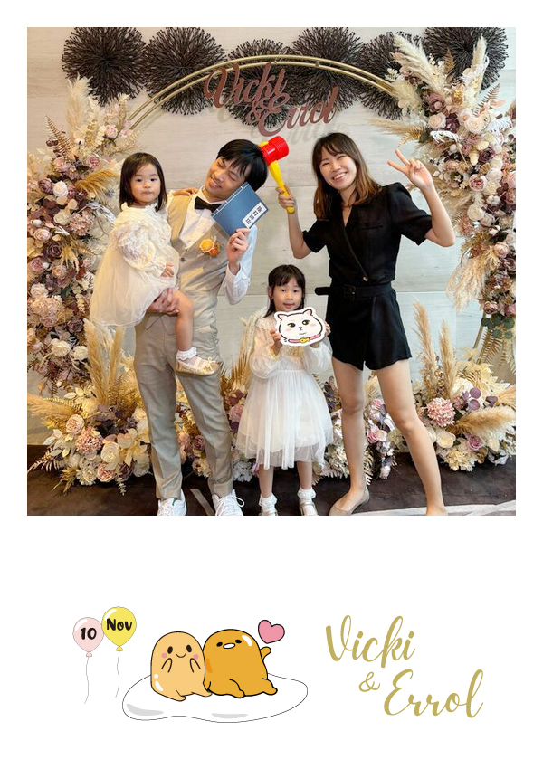 LomoBooth 婚禮即影即印完成相片,一位男賓客、女賓客與兩位小朋友於婚禮花卉佈置前手持趣味拍照道具合照,配搭 Vicki & Errol 可愛角色及氣球圖案 LomoBooth 相框